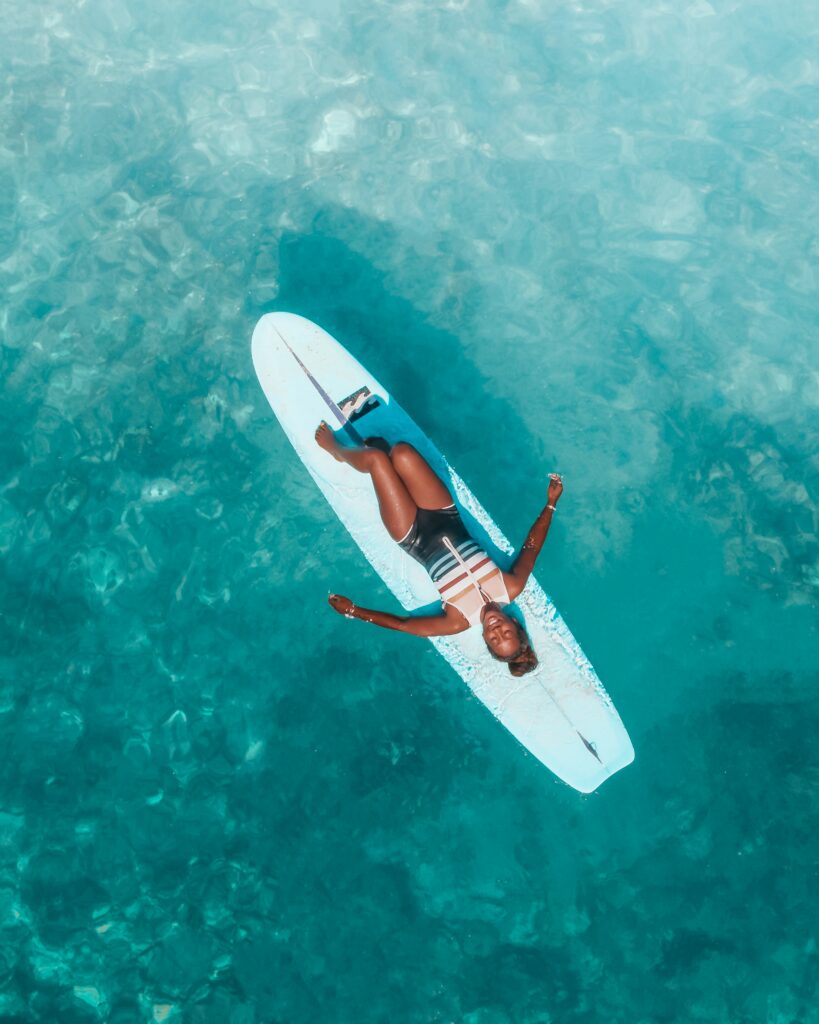 Lady relaxing on surf board to improve mental health and wellbeing